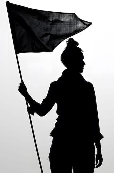Silhouette noire d'une femme tenant un drapeau noir, l'image capture un moment d'assurance et d'expression, isolée sur fond gris.